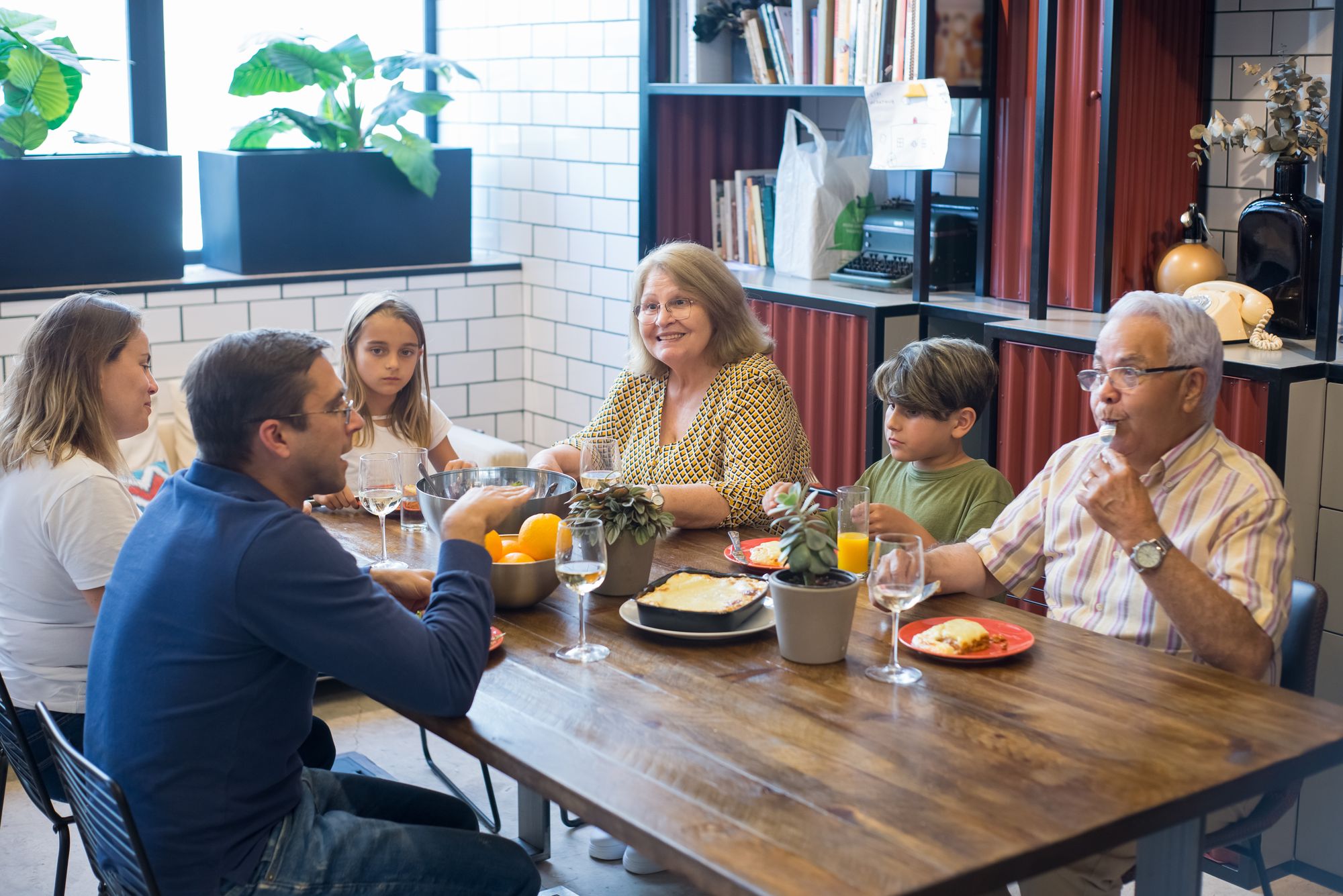 Three generations talking together around a dining table